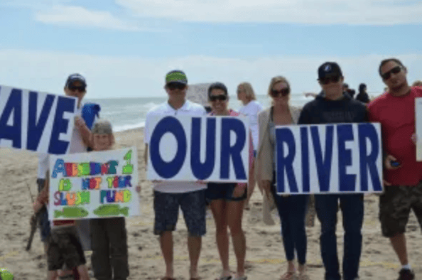 Beach Rally and Patrick Murphy gives President Obama a bottle of dirty river water.